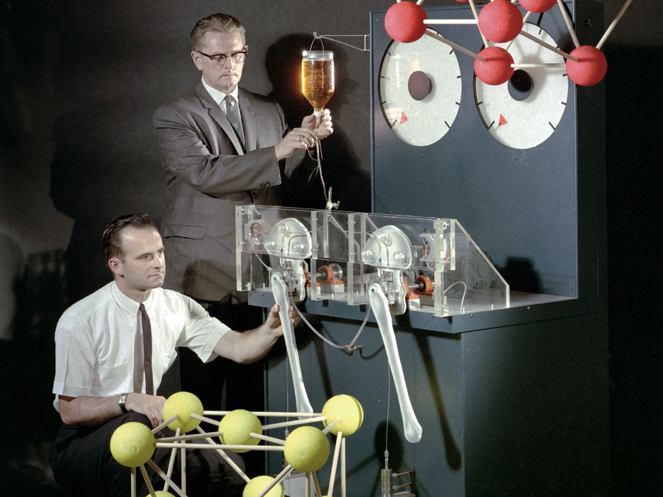 Robert Johnson sets the lubricant flow while Donald Buckley adjusts the bearing specimen on an artificial hip simulator 